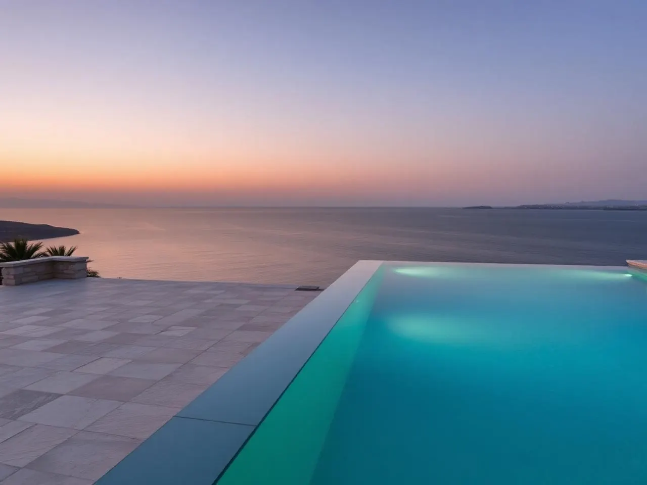 Private infinity pool at dusk on the terrace of a luxury villa in Malta with sea views